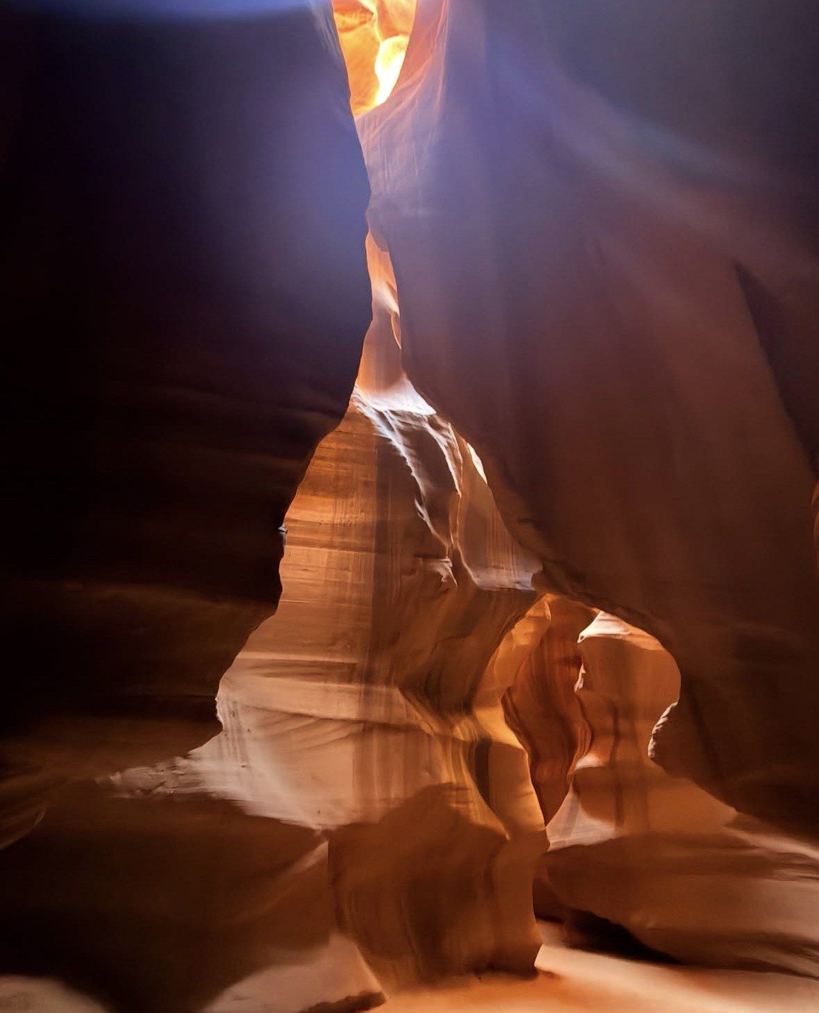 Dark chamber lit by a warm shaft falling from above