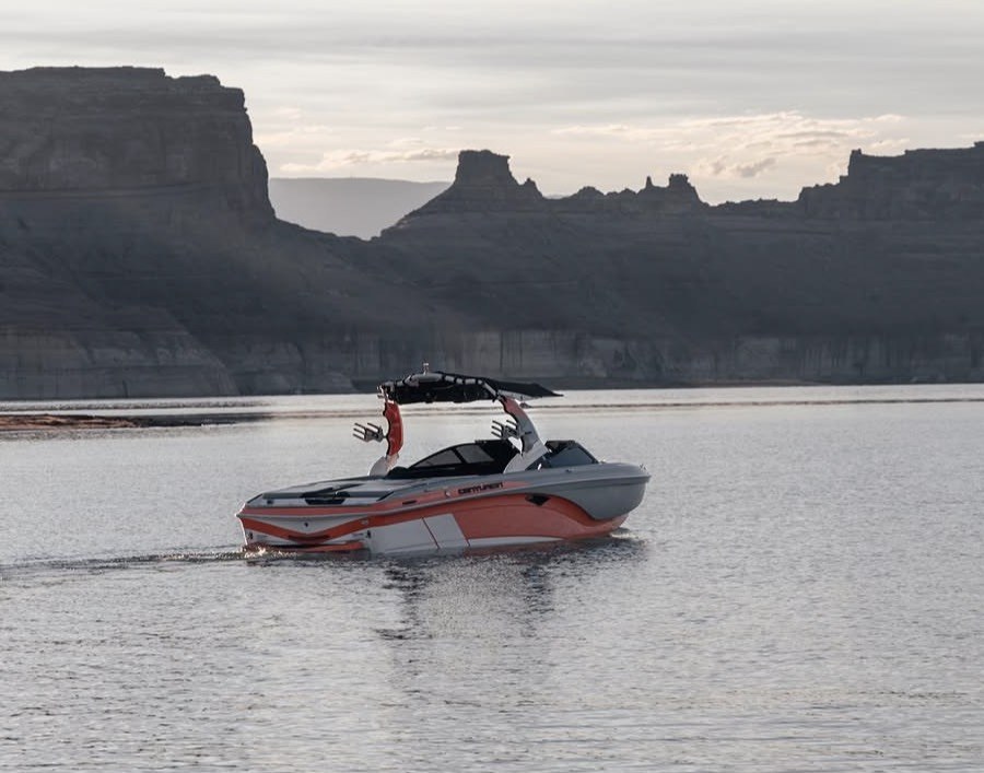 Motorboat crossing calm Lake Powell water below sandstone cliffs