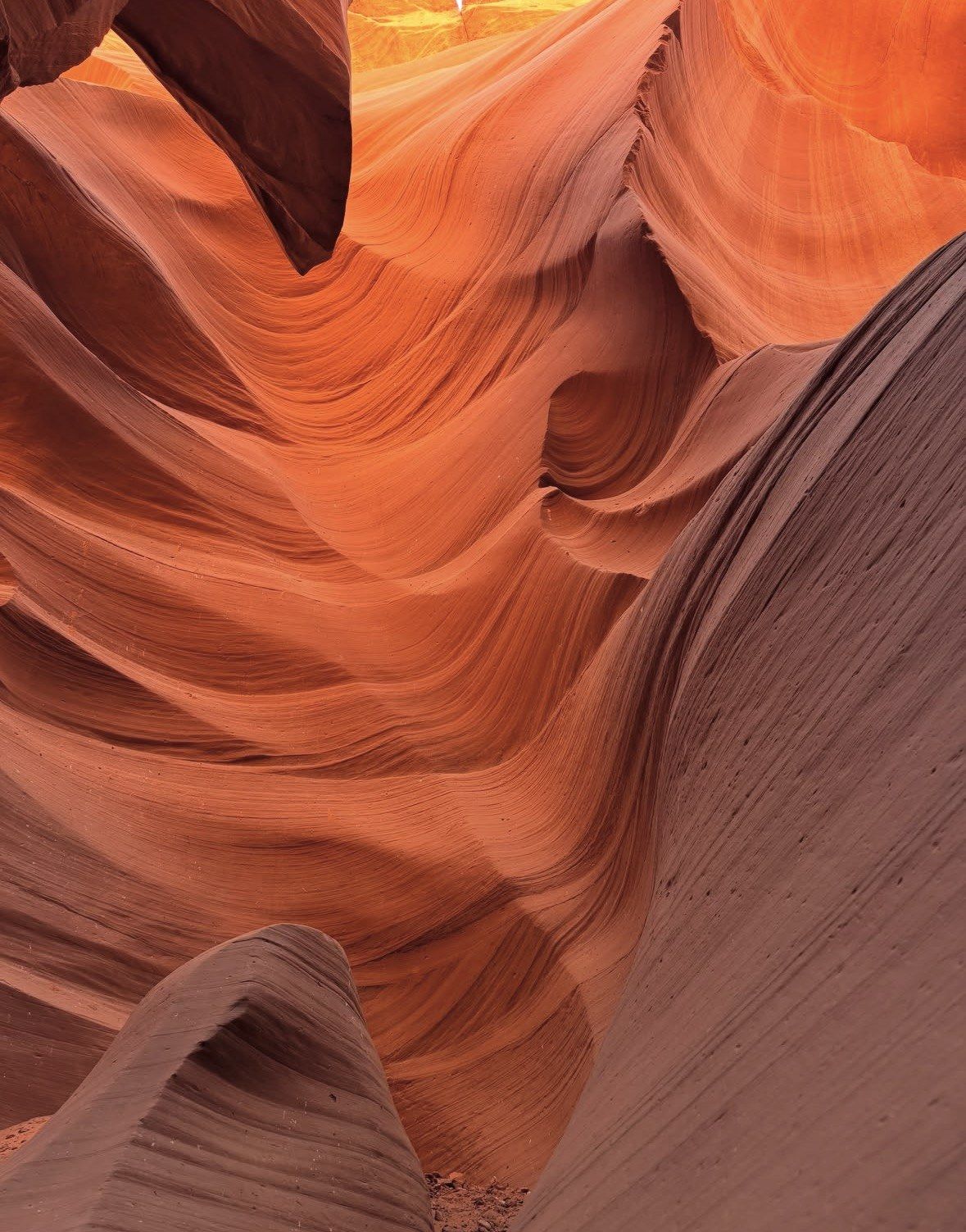 Layered sandstone folds rippling like waves across Antelope Canyon walls